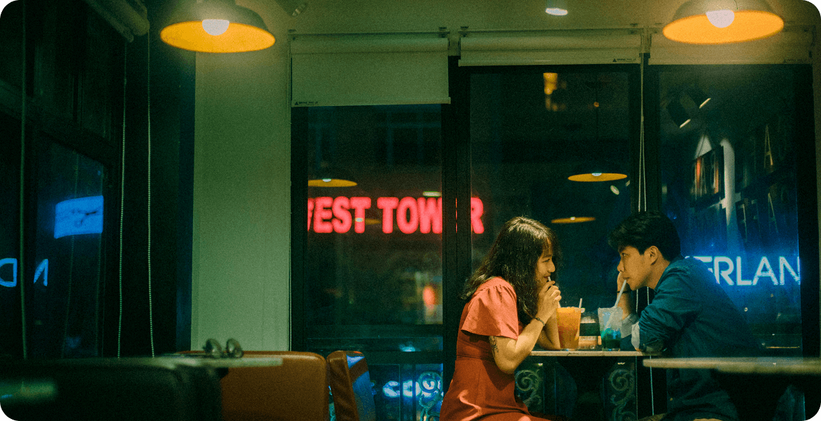 Couple at dimly lit cafe or bar having conversation