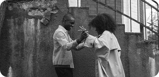 Couple dancing outdoors with concrete wall background